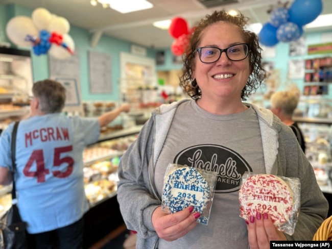 Bakery owner Kathleen Lochel holds sugar cookies in Lochel Bakery, Tuesday, Sept. 24, 2024, in Hatboro, a suburb of Philadelphia. (AP Photo/Tassanee Vejpongsa)