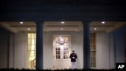 A Marine Honor Guard stands watch at the entrance to the West Wing of the White House Monday night, Sept. 30, 2013. President Barack Obama ramped up pressure on Republicans Monday to avoid a post-midnight government shutdown, saying that failure to…