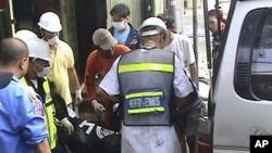 Rescuers load the bodies of victims into an ambulance following a fire that gutted the Bed and Breakfast Pension House in Tuguegarao city, Cagayan province in Northern Philippines early Sunday, 19 Dec 2010