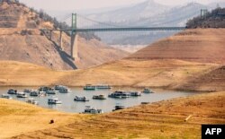 Rumah perahu berada di bagian air yang sempit di Danau Oroville yang mengering, di Oroville, California, 5 September 2021.Danau Oroville saat ini memiliki kapasitas 23% dan mengalami tingkat kekeringan yang ekstrem. (JOSH EDELSON / AFP)