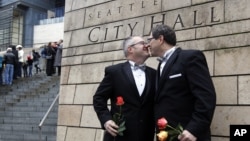 Terry Gilbert, left, kisses his husband Paul Beppler after wedding at Seattle City Hall, becoming among the first gay couples to legally wed in the state, December 9, 2012. 