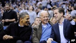 President Barack Obama talks with Vice President Joe Biden, center, and his son Hunter Biden, right, at the Duke Georgetown NCAA college basketball game, Jan. 30, 2010, in Washington. 