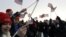 Spectators wave American flags on the National Mall in Washington, Jan. 21, 2013, before the start of President Barack Obama's ceremonial swearing-in ceremony during the 57th Presidential Inauguration.
