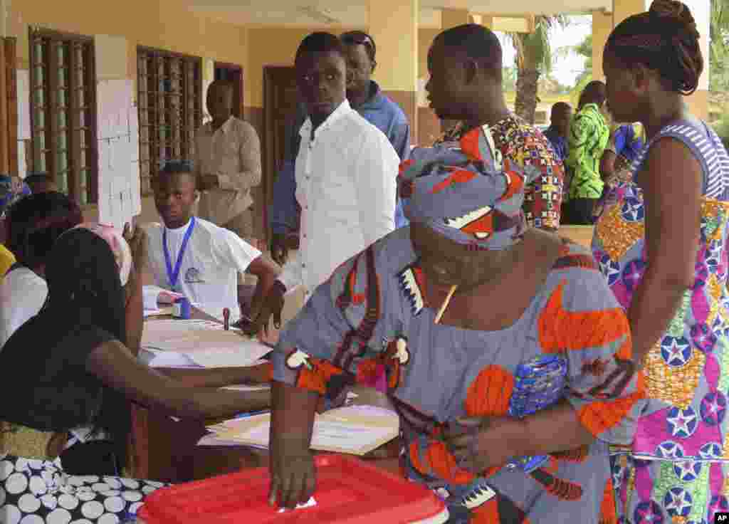 Une femme met son bulletin dans l'urne au bureau de vote de Seme Podji, au Bénin, le 6 mars 2016. (AP Photo/Virgile Ahissou)