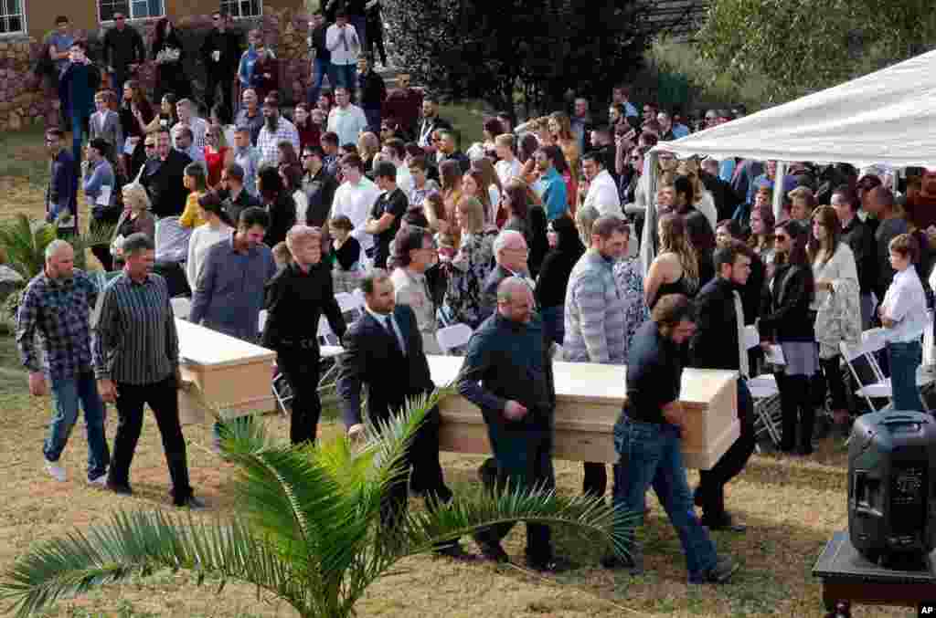 Men carry the remains of Dawna Ray Langford, 43, and her sons, Trevor, 11, and Rogan, 2, who were killed by drug cartel gunmen, before they are buried at the cemetery in La Mora, Sonora state, Mexico.