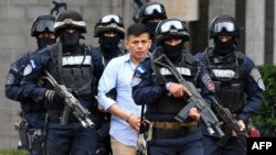 FILE - Honduran drug trafficker Sergio Neftali Mejia Duarte, aka "El Compa," is escorted by members of the Tigres Special Forces following his arrest in Amarateca, 20 km north of Tegucigalpa, Aug. 20, 2017.