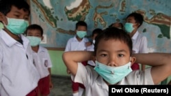 Para siswa sekolah dasar menggunakan masker di dalam kelas mereka di Desa Candi Binangun di Sleman, Yogyakarta. Ikatan Dokter Anak Indonesia (IDAI) mencatat pada November 2021 sebanyak 1.346 anak mengalami diabetes. (Foto: REUTERS/Dwi Oblo)