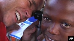 Frederic Rondeau of Starkey Hearing Foundation outfits a hearing aid for a Haitian child, Marchand Dessalines, Haiti, January 9, 2012.