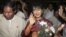 Myanmar opposition leader Aung San Suu Kyi, center, arrives at Rangoon International airport before departing for India in Rangoon, Burma Nov. 12, 2012.
