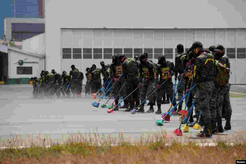 Soldiers sweep ashes from the Pacaya volcano at the tarmac of La Aurora International Airport in Guatemala City, Guatemala, March 23, 2021.