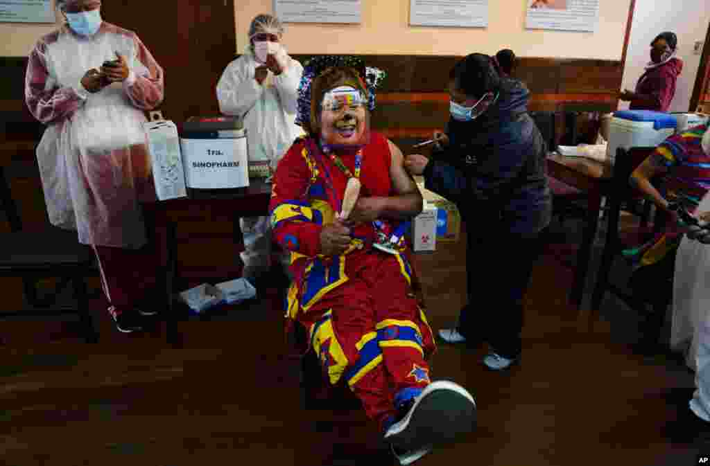 볼리비아 라파스의 산안드레스대학에 마련된 18~30세 주민 대상 시노팜 신종 코로나바이러스 백신 접종소에서 광대가 백신 주사를 맞고 있다.