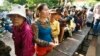 Cambodian villagers line up to cast their vote in the country's national election at a polling station at Chak Angre Leu pagoda, in Phnom Penh, Cambodia, Sunday, July 28, 2013. 