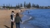 Orang-orang menikmati sinar matahari, ketika negara bagian Victoria mulai mengurangi pembatasan Covid-19, di pantai Elwood di Melbourne, Australia, 14 September 2020. (Foto: AAP/James Ross via Reuters)