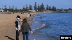 People enjoy the sunshine, as Victoria state begins easing coronavirus disease (COVID-19) restrictions, at Elwood beach in Melbourne, Australia, Sept. 14, 2020. (AAP Image/James Ross via Reuters) 