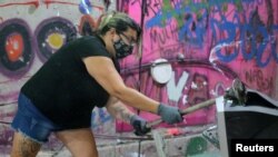 Luciana Holanda smashes a computer monitor at the Rage Room, a place where people can destroy everyday objects to vent their anger, in Sao Paulo, Brazil, Feb. 19, 2021.