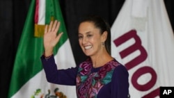 La candidata presidencial del partido gobernante, Claudia Sheinbaum, saluda antes de dirigirse a sus partidarios en la Ciudad de México, la madrugada del 3 de junio de 2024.