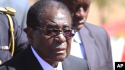 FILE - Zimbabwean President, Robert Mugabe, attends the burial of Major General Bandama who died after a short illness at the National Heroes acre in Harare, July, 17, 2014.