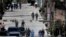 FILE - Workers from the Ministry of Health are accompanied by soldiers and police as they investigate in a cordoned off neighborhood after multiple people tested positive for the new coronavirus, in Tegucigalpa, Honduras, March 17, 2020.