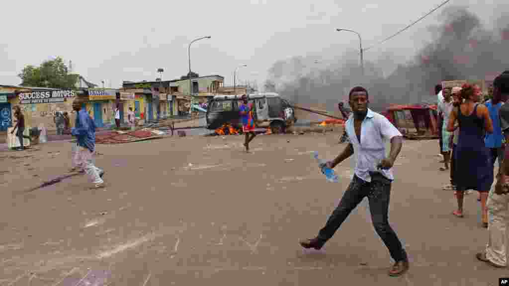 Des manifestants anti gouvernementaux brûlent des pneus et un véhicule lors d&#39;une manifestation contre la modification de la loi électorale qui pourrait retarder l&#39;élection prévue en 2016, dans la ville de Kinshasa, République démocratique du Congo, le lundi 19 janvier 2015,