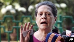 India's ruling Congress party president Sonia Gandhi, right addresses the media as Vice President Rahul Gandhi smiles in New Delhi, Dec. 8, 2013.