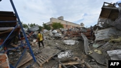 Мужчина среди обломков разрушенных складов и мастерских в результате российского ракетного удара по Харькову в ночь на 31 июля 2023 года