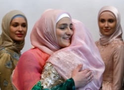 FILE - Aishat Kadyrova (L), head of the Firdaws fashion house and daughter of the Chechen Republic leader Ramzan Kadyrov, embraces a participant during the Mercedes-Benz Fashion Week Russia in Moscow, Russia, March 17, 2017.