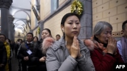 FILE - Chinese Christians attend Christmas Eve Mass at a Catholic church in Beijing, Dec. 24, 2016.