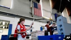 FILE - Election workers process mail-in and absentee ballots to scan for the 2020 U.S. general election at West Chester University, in West Chester, Pennsylvania, Nov. 4, 2020. 