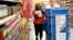 FILE - Walmart associate Alicia Carter fulfills online grocery orders in Houston, Nov. 9, 2018. Amazon and Walmart on April 18, 2019, kicked off a pilot program that lets shoppers on government food assistance in New York to shop and pay for their groceries online.