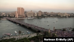 FILE - Supporters of Egypt's top military officer, Gen. Abdel-Fatah el-Sissi, march over a bridge leading to Tahrir Square in Cairo after the ouster of democratically-elected Egyptian President Mohammed Morsi, July 26, 2013.