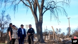 President Donald Trump and archetypal  woman  Melania Trump locomotion  with Jason Hing, main  lawman  of exigency  services astatine  the Los Angles Fire Department, left, and Capt. Jeff Brown, main  of Station 69, arsenic  they circuit  a vicinity  affected by caller    wildfires successful  Los Angeles, Jan. 24, 2025.