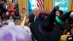 Presiden AS Donald Trump menghibur anak-anak yang mengenakan kostum Halloween di Gedung Putih, hari Jumat (27/10).