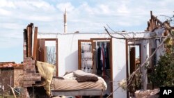 A tornado-damaged bedroom with clothes hanging in the closet is pictured in Oklahoma City, Oklahoma May 22, 2013. 