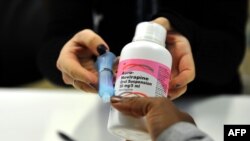 FILE - A woman gets antiretroviral drugs at the Chris Hani Baragwanath Hospital, South Africa's largest public hospital, in Soweto.