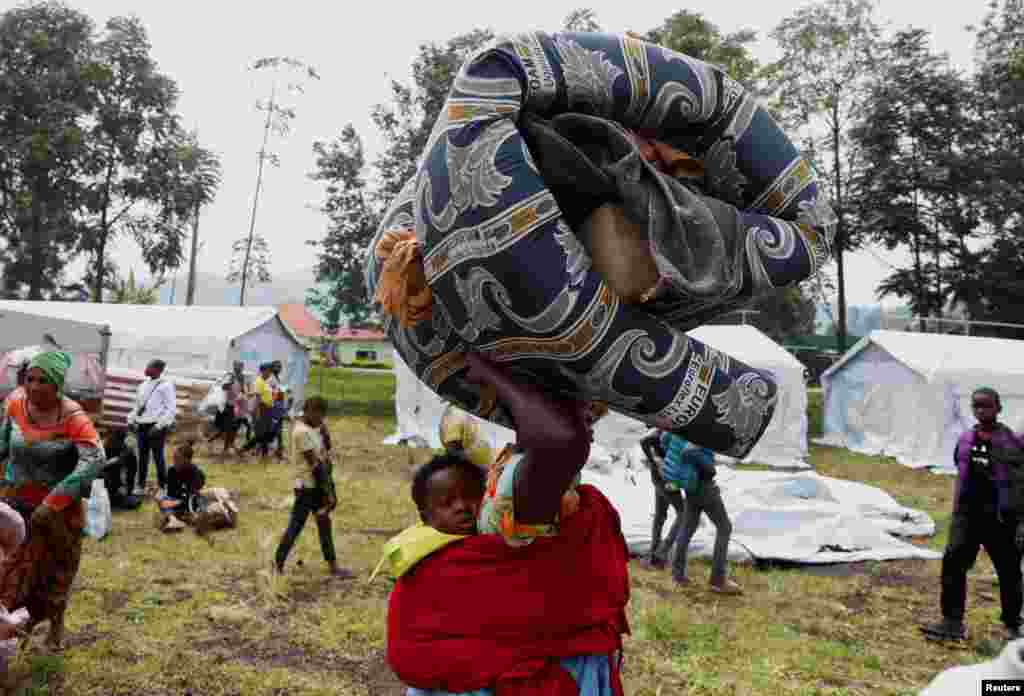 A Congolese woman carries her child fleeing from Goma, arrive at a reception center in Rugerero near Gisenyi, in Rubavu district, Rwanda, Jan. 28, 2025.