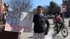 Seorang demonstran membawa poster berisi dukungan terhadap pekerja federal dalam aksi protes di luar Gedung Putih di Washington, pada 10 Februari 2025. (Foto: Reuters/Kevin Lamarque)