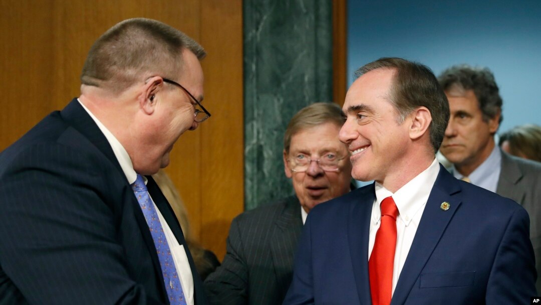 FILE - The Senate Veterans' Affairs Committee Ranking member Jon Tester, D-Mont., left, with committee chairman Sen. Johnny Isakson, R-Ga., center, shakes hands with Veterans Affairs Secretary-designate Dr. David Shulkin on Capitol Hill in Washington, Feb