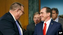 FILE - The Senate Veterans' Affairs Committee Ranking member Jon Tester, D-Mont., left, with committee chairman Sen. Johnny Isakson, R-Ga., center, shakes hands with Veterans Affairs Secretary-designate Dr. David Shulkin on Capitol Hill in Washington, Feb