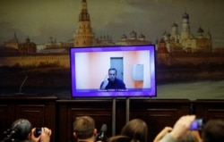 FILE - Russian opposition leader Alexei Navalny is seen on a screen via a video link during a court hearing to consider an appeal on his arrest outside Moscow, Russia, Jan. 28, 2021.