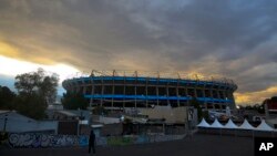 A man walks outside Azteca Stadium in Mexico City, at dusk, Nov. 13, 2018. 