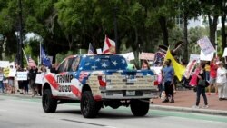 A truck supporting protesters demanding Florida businesses and government reopen, honks at a gathering in downtown Orlando, Florida, April 17, 2020.