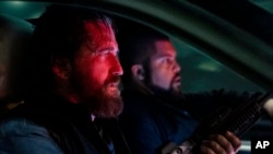 This image released by Lionsgate shows Gerard Butler, left, and O'Shea Jackson Jr. in a scene from "Den of Thieves 2: Pantera." (Rico Torres/Lionsgate via AP)