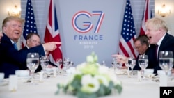 U.S. President Donald Trump, left, and Britain's Prime Minister Boris Johnson attend a working breakfast at the Hotel du Palais on the sidelines of the G-7 summit in Biarritz, France, Sunday, Aug. 25, 2019. (AP Photo/Andrew Harnik)