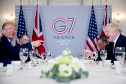 U.S. President Donald Trump, left, and Britain's Prime Minister Boris Johnson attend a working breakfast at the Hotel du Palais on the sidelines of the G-7 summit in Biarritz, France, Sunday, Aug. 25, 2019.