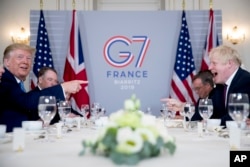 U.S. President Donald Trump, left, and Britain's Prime Minister Boris Johnson attend a working breakfast at the Hotel du Palais on the sidelines of the G-7 summit in Biarritz, France, Sunday, Aug. 25, 2019. (AP Photo/Andrew Harnik)