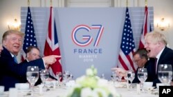 President Donald Trump, left, and Britain's Prime Minister Boris Johnson attend a working breakfast on the sidelines of the G-7 summit in Biarritz, France, Aug. 25, 2019.