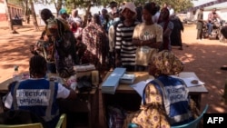 TOPSHOT - Officials from the Electoral Commission Ghana check voter's IDs at a polling station in Walewale on December 7, 2024 during the Ghana presidential and parliamentary elections. (Photo by Caroline Chauvet Abalo / AFP)