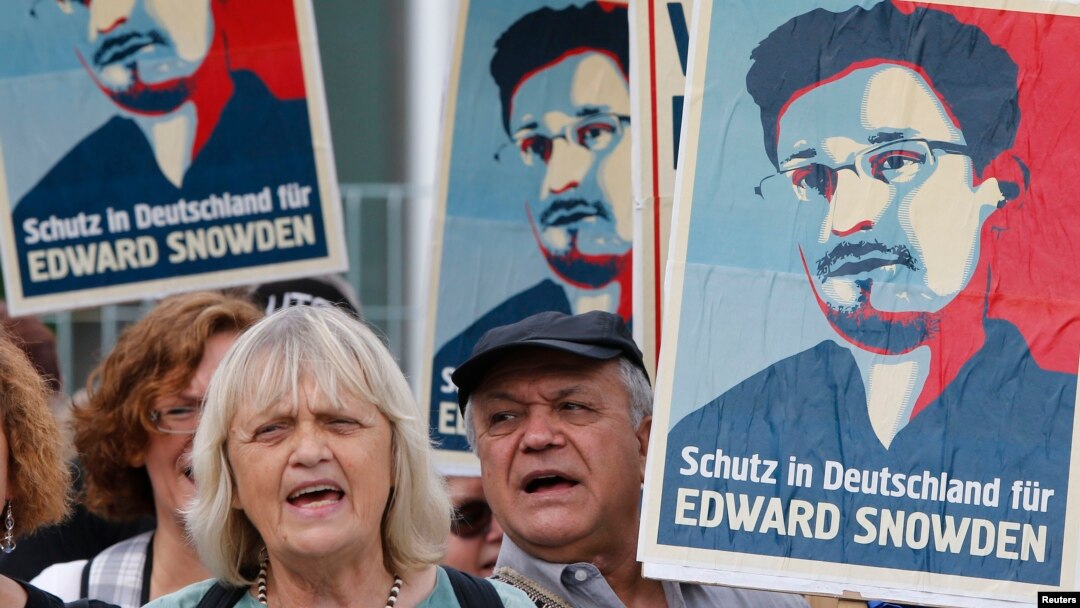 Para demonstran memegang poster-poster dalam unjuk rasa mendukung mantan kontraktor intelijen AS Edward Snowden di Berlin (4/7). Tulisan di poster bertuliskan "Tempat penampungan di Jerman untuk Edward Snowden". (Reuters/Tobias Schwarz) 