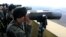 South Korean soldiers look at North Korea through binoculars from Dora Observation Post near the border village of Panmunjom, April 10, 2013.