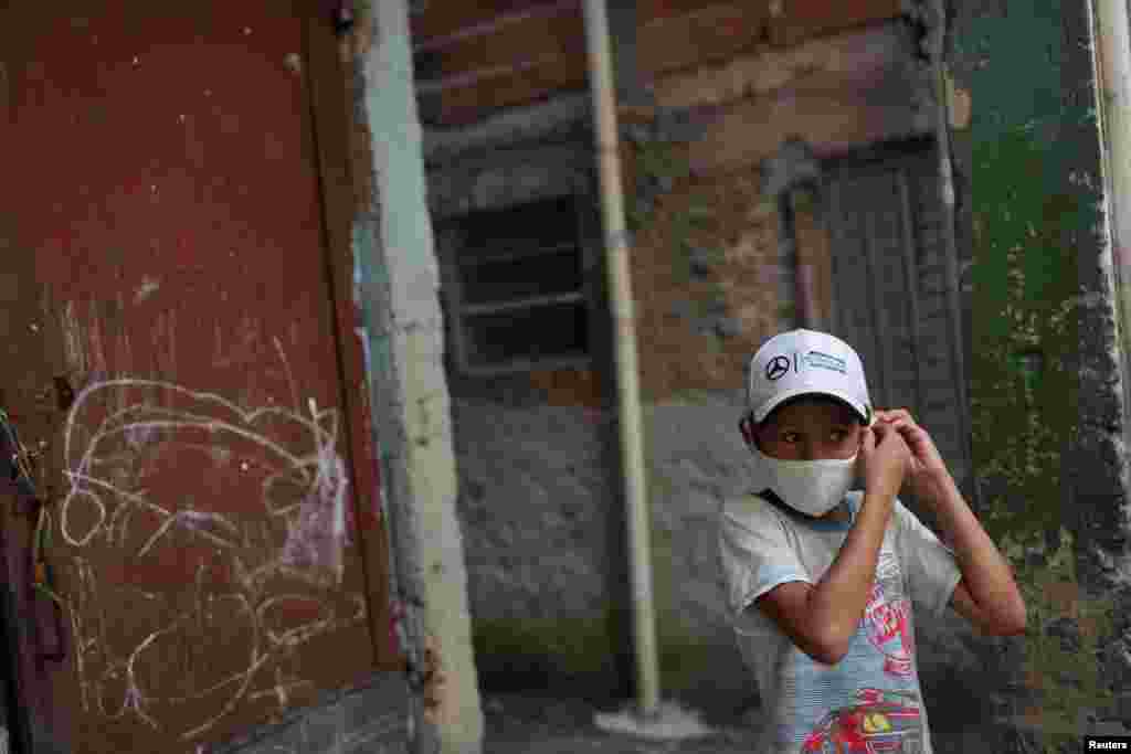 Brasil: Un niño ajusta su tapa bocas en el barrio marginal de Paraisópolis, el más grande de la ciudad de Sao Paulo. En ese lugar, los residentes contrataron un servicio médico privado las 24 horas para combatir al coronavirus.